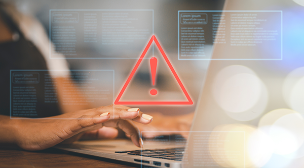 developer using computer laptop with triangle caution warning sign